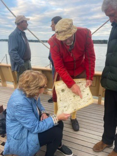 A JYF donor looks at a map with an interpreter aboard the Goodspeed