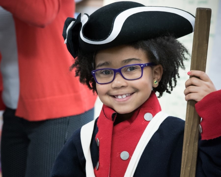 A young child dressed in a Continental Army uniform